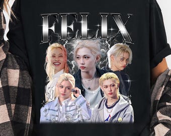 May include: Black t-shirt featuring the name "FELIX" in a silver, metallic font. The shirt has a collage of images of a person with blonde hair. The background has a lightning bolt design.