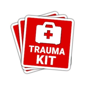 May include: A stack of red square stickers with white borders. Each sticker features a white first aid kit icon with a red cross and the words "TRAUMA KIT" in bold white letters. The stickers are slightly overlapping.