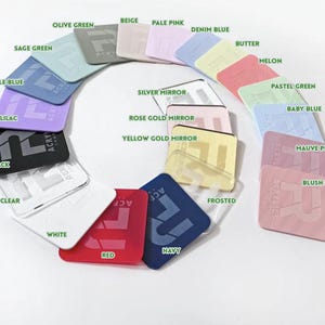 May include: A collection of square acrylic samples in various colors, including Olive Green, Beige, Pale Pink, Denim Blue, and Red. Each sample has the word "ACRYLICS" or "ACRY" printed on it. The samples are arranged in a circular pattern.