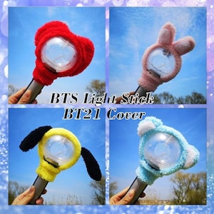 May include: A montage of four BTS Light Stick BT21 Covers. The covers are in red heart, pink bunny, yellow with black ears, and blue bear designs. Each cover fits over a light stick with a clear, round light.