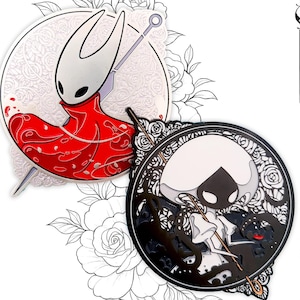 May include: Two enamel pins featuring characters from a video game. One pin shows a character in a red cloak with a spear, set against a white floral background. The other pin is black and white with a character holding a staff.