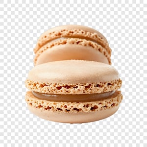 May include: Two beige macarons with a light brown filling are stacked in front of a transparent background. The cookies have a textured, porous edge. The filling is visible between the two halves of the front macaron.