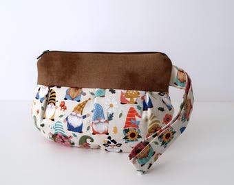 Puede incluir: Una bolsa de tela marrón y blanca con un patrón de gnomos. La bolsa tiene un asa de tela marrón y un cierre de cremallera.