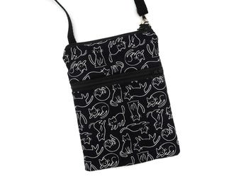 Puede incluir: Un bolso bandolera negro con un patrón repetitivo de líneas blancas que muestra gatos en diferentes posturas. El bolso incluye un bolsillo frontal con cremallera, un compartimento principal y una correa negra fina y ajustable sujeta con herrajes de metal plateado.