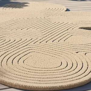 Puede incluir: Una alfombra de color beige con una superficie texturizada que presenta un patr&oacute;n repetitivo de c&iacute;rculos conc&eacute;ntricos y formas geom&eacute;tricas redondeadas. La alfombra tiene una construcci&oacute;n de pelo grueso con surcos profundos.