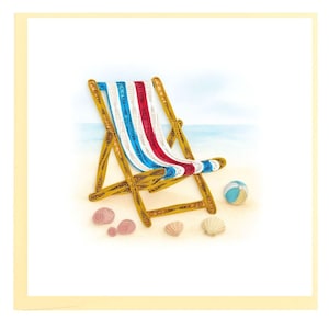 May include: A beach-themed greeting card featuring a paper quilling design. The card depicts a wooden beach chair with a red, white, and blue striped seat, a beach ball, and seashells on a sandy surface.