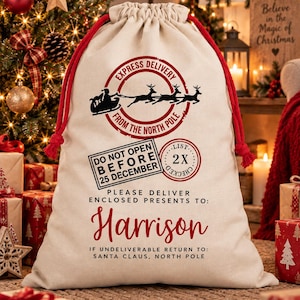 May include: A beige drawstring gift sack with red cords featuring a black graphic of a sleigh and reindeer, a circular stamp reading EXPRESS DELIVERY FROM THE NORTH POLE, and text stating DO NOT OPEN BEFORE 25 DECEMBER and Harrison.
