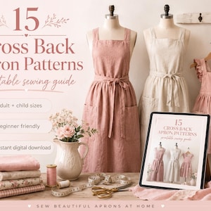 May include: A printable sewing guide titled 15 Cross Back Apron Patterns featuring three mannequins wearing pink and beige linen aprons. The display includes a tablet showing the guide, a stack of folded fabrics, a ceramic pitcher, and sewing tools.