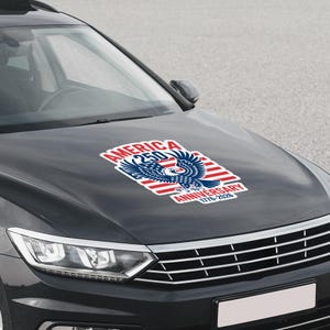 K&ouml;nnte beinhalten: Ein Aufkleber auf einer Motorhaube zeigt ein patriotisches Design zum 250. Jahrestag Amerikas. Der Aufkleber enth&auml;lt einen Wei&szlig;kopfseeadler, rot-wei&szlig;e Streifen und den Text "AMERICA 250 ANNIVERSARY 1776-2026" in Rot und Blau.