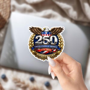 K&ouml;nnte beinhalten: Ein Aufkleber mit einem patriotischen Design zum 250. Jahrestag der Vereinigten Staaten von Amerika. Das Design umfasst eine silberne "250" in einem blauen Kreis, einen Adler mit ausgebreiteten Fl&uuml;geln und den Text "United States of America 1776-2026 Anniversary."