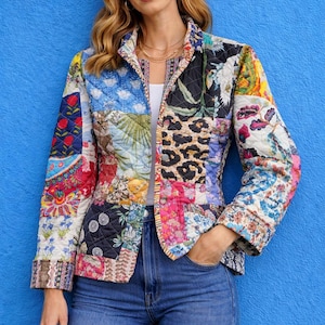 May include: A quilted patchwork jacket with a vibrant mix of floral, animal print, and geometric patterns. The jacket features a collared neckline and is worn with blue jeans. The background is a solid blue wall.