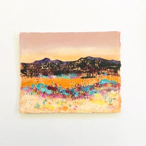 May include: A painting of a desert landscape with a mountain range in the background. The foreground is a field of colorful wildflowers and green plants. The sky is a soft pink and orange.