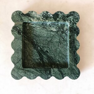May include: A green marble tray with a scalloped edge. The tray has a square inner section.