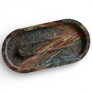 May include: An oval-shaped stone tray featuring a polished surface with a complex pattern of deep forest green, dark charcoal, and prominent rust-colored veins running throughout the material, creating a natural marbled appearance.