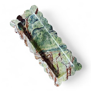 May include: A green, brown, and white marble serving tray with a scalloped edge. The tray has a rectangular shape and is perfect for serving snacks or appetizers.