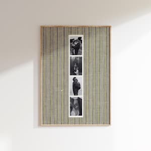 May include: A rectangular framed wall art piece with a vertical striped pattern in olive green and cream. Four black and white photographs are displayed vertically in the center. The frame has a natural wood finish.