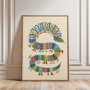 Puede incluir: Una impresión artística enmarcada con una ilustración caprichosa de una serpiente colorida. El cuerpo de la serpiente está compuesto por segmentos estampados en varios colores, con pequeños pies que llevan zapatos. La cabeza de la serpiente es verde con una lengua roja.