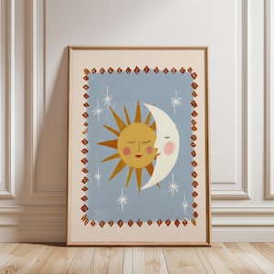 May include: Framed art print featuring a whimsical illustration of a smiling sun and moon embracing. The sun is yellow with orange rays, and the moon is white. Set against a light blue background with stars and a decorative border.
