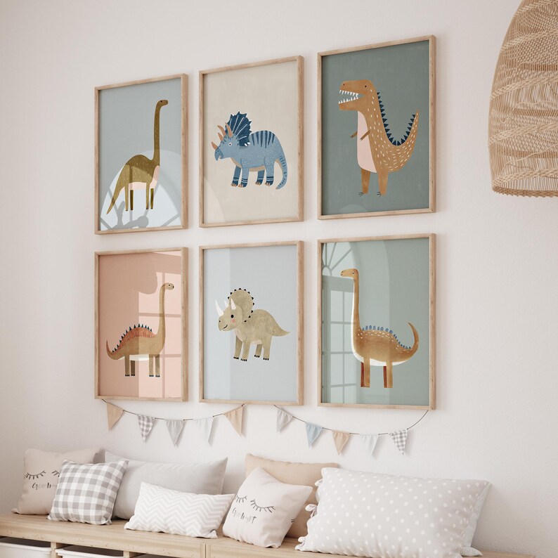 May include: Six framed dinosaur art prints in pastel shades. Each print showcases a different dinosaur illustration, such as a Brontosaurus, Triceratops, and T-Rex. The frames are light wood, and the theme is ideal for a nursery or a child's bedroom.