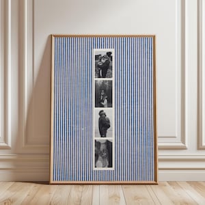 May include: A framed piece of art featuring four black and white photographs. The background is a blue and white striped fabric. The frame is a light brown color.