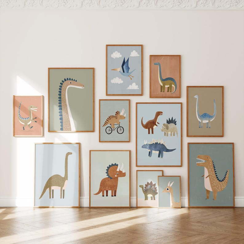 May include: A set of framed dinosaur art prints. The illustrations depict various dinosaurs in a cartoon style, using blues, greens, browns, and pinks. The frames are a warm brown colour, and the art is displayed on a white wall.