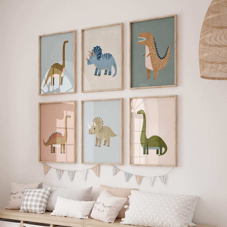 May include: Six framed dinosaur art prints in pastel shades. Each print showcases a different dinosaur illustration, such as a Brontosaurus and a Triceratops. The frames are light wood, and the overall theme is suitable for a nursery or children's room.