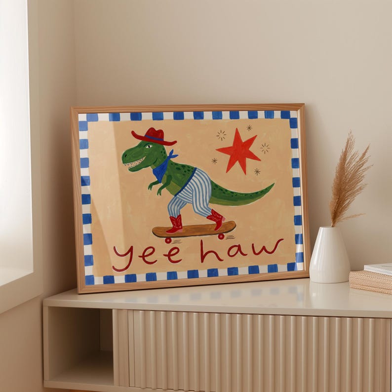 A framed illustration of a dinosaur riding a skateboard, with the text "yeehaw" below the image.