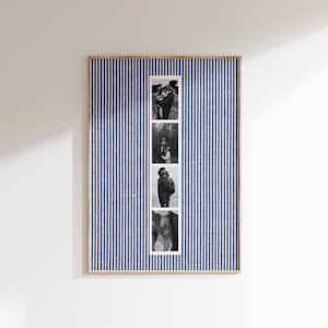 May include: A framed photo display featuring a blue and white striped background. Four black and white photographs are vertically aligned in a white strip. The frame is a light wood color, and the display is mounted on a white wall.