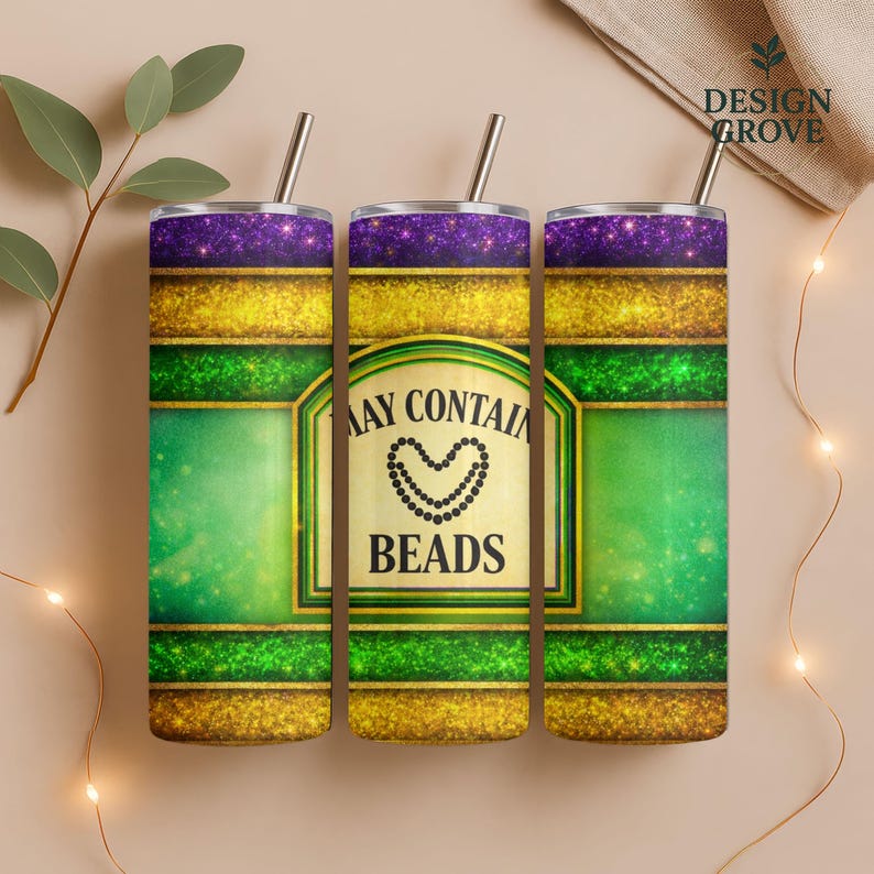 May include: Three stainless steel tumblers with straws, featuring a purple glitter top, gold glitter band, and green center. The center label reads "MAY CONTAIN BEADS" with a beaded heart design. The tumblers are designed with a Mardi Gras theme.