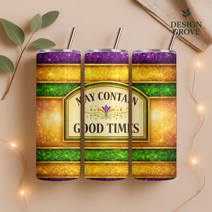 May include: Three stainless steel tumblers with straws, featuring a design with purple, gold, and green bands. The center tumbler displays the text "MAY CONTAIN GOOD TIMES" in a decorative frame. The tumblers are designed for beverages.