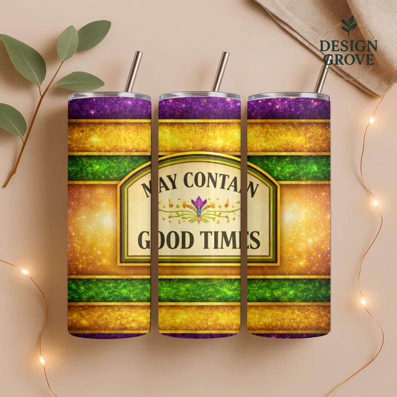 May include: Three stainless steel tumblers with straws, featuring a design with purple, gold, and green bands. The center tumbler displays the text "MAY CONTAIN GOOD TIMES" in a decorative frame. The tumblers are designed for beverages.