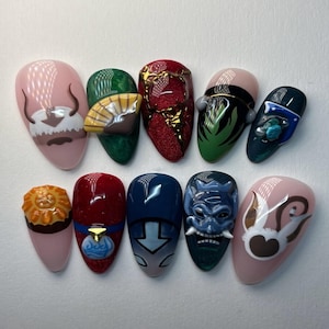 May include: A set of ten almond-shaped, decorated artificial nails. Each nail features a different design, including cartoon characters, patterns, and 3D embellishments in various colors like pink, green, red, blue, and gold. The designs are inspired by a popular animated series.