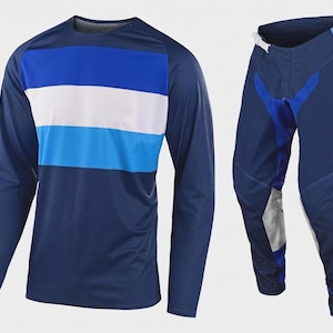 Puede incluir: Un conjunto de camiseta de manga larga azul marino y pantalón a juego. La camiseta presenta rayas horizontales azules y blancas en el pecho. Los pantalones tienen detalles en azul y blanco.