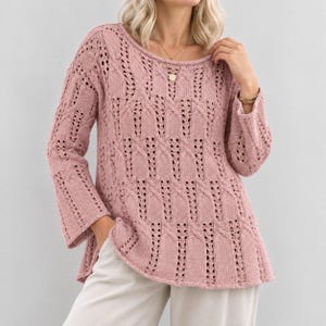 May include: A dusty rose long-sleeved sweater featuring a round neckline and an intricate openwork knit pattern with vertical cable-like columns. The garment has a relaxed fit with slightly flared sleeves and a textured, breathable knit construction.