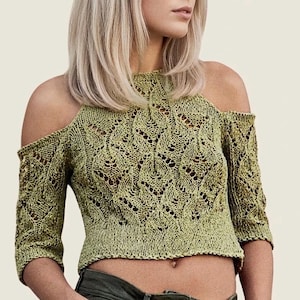 Può includere: Un top in maglia verde chiaro con spalle scoperte e un motivo traforato dettagliato. Il top ha maniche a tre quarti e un collo alto. Il design corto rivela l'addome. La maglia è di un colore verde tenue e morbido.