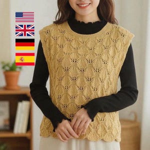 May include: A sleeveless, open-weave knit vest in a light tan color. The vest features a repeating diamond pattern and a scalloped hem. The vest is worn over a black long-sleeved shirt. The overall style is casual and suitable for layering.