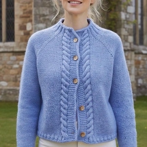 Può includere: Un cardigan azzurro con un motivo a trecce sulla parte anteriore e intorno al colletto. Il maglione ha maniche lunghe e bottoni in legno. Lo stile è classico e confortevole.