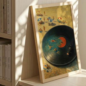 May include: Framed art print featuring a beach scene with people swimming in a vinyl record. The artwork has a light wooden frame and is displayed on a wooden surface next to a bookshelf and a stack of books.