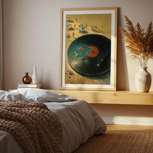 May include: Framed art print depicting a vinyl record with swimmers in the grooves, set against a beach scene. The artwork features a wooden frame and is displayed above a bed with a brown knitted blanket.