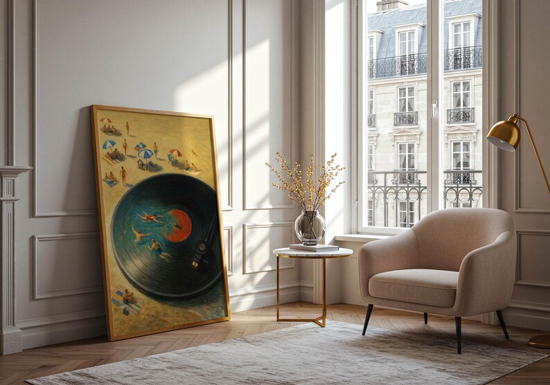 May include: A framed artwork depicting a beach scene within a vinyl record design. The artwork features figures on a sandy beach and swimmers in the water, with a warm color palette. The frame is a light wood color, and the artwork is leaning against a white wall.