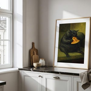 May include: Framed art print featuring a black cat seated on a green sofa, holding and eating a slice of pizza. The artwork is displayed in a light wood frame, adding a touch of whimsy to any room. The print is set against a neutral background.