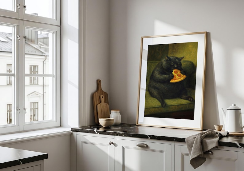 May include: Framed art print featuring a black cat seated on a green sofa, holding and eating a slice of pizza. The artwork is displayed in a light wood frame, adding a touch of whimsy to any room. The print is set against a neutral background.