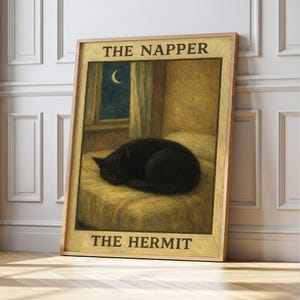 May include: A framed print featuring a sleeping black cat on a bed, with a window showing a crescent moon. The text at the top reads "THE NAPPER" and at the bottom "THE HERMIT". The artwork has a vintage, painterly style.