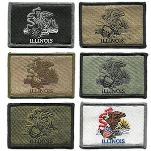 May include: Rectangular embroidered patches featuring the Illinois state seal. The patches come in various colors, including black, tan, and green. Each patch displays an eagle, the word "ILLINOIS", and other design elements. The patches are likely for clothing or accessories.