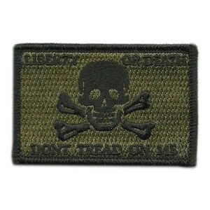 May include: A rectangular olive green embroidered patch featuring a black skull and crossbones in the center. The text LIBERTY OR DEATH is stitched in black above the skull, and DONT TREAD ON ME is stitched in black below the skull design.