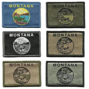 May include: A collection of six embroidered patches featuring the word "MONTANA" above a circular emblem. The patches vary in color, including blue, olive green, black, and tan. The emblem depicts a landscape with a lake, mountains, and a setting sun.