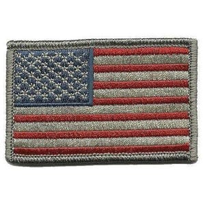 Op de afbeelding: Een rechthoekige geborduurde patch met de vlag van de Verenigde Staten in een gedempt kleurenpalet. Het ontwerp bevat een donkerblauw kanton met lichte sterpatronen en afwisselende horizontale strepen in donkerrood en gedempt grijs.