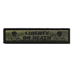 May include: A rectangular olive green embroidered patch with a black border. The text LIBERTY OR DEATH is centered in black capital letters, flanked on both sides by a black skull and crossbones icon on a textured fabric background.