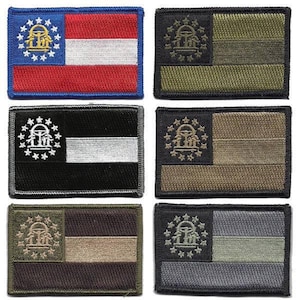 May include: A collection of six embroidered patches featuring the flag of Georgia. The patches display the state flag in various color schemes, including the traditional red, white, and blue, as well as black, green, and gray variations. Each patch has a rectangular shape.