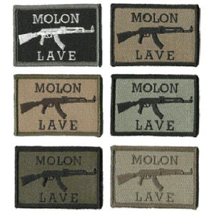 May include: A collection of six rectangular patches. Each patch features an image of an assault rifle and the words "MOLON LAVE" in capital letters. The patches are in various shades of green, brown, and black.